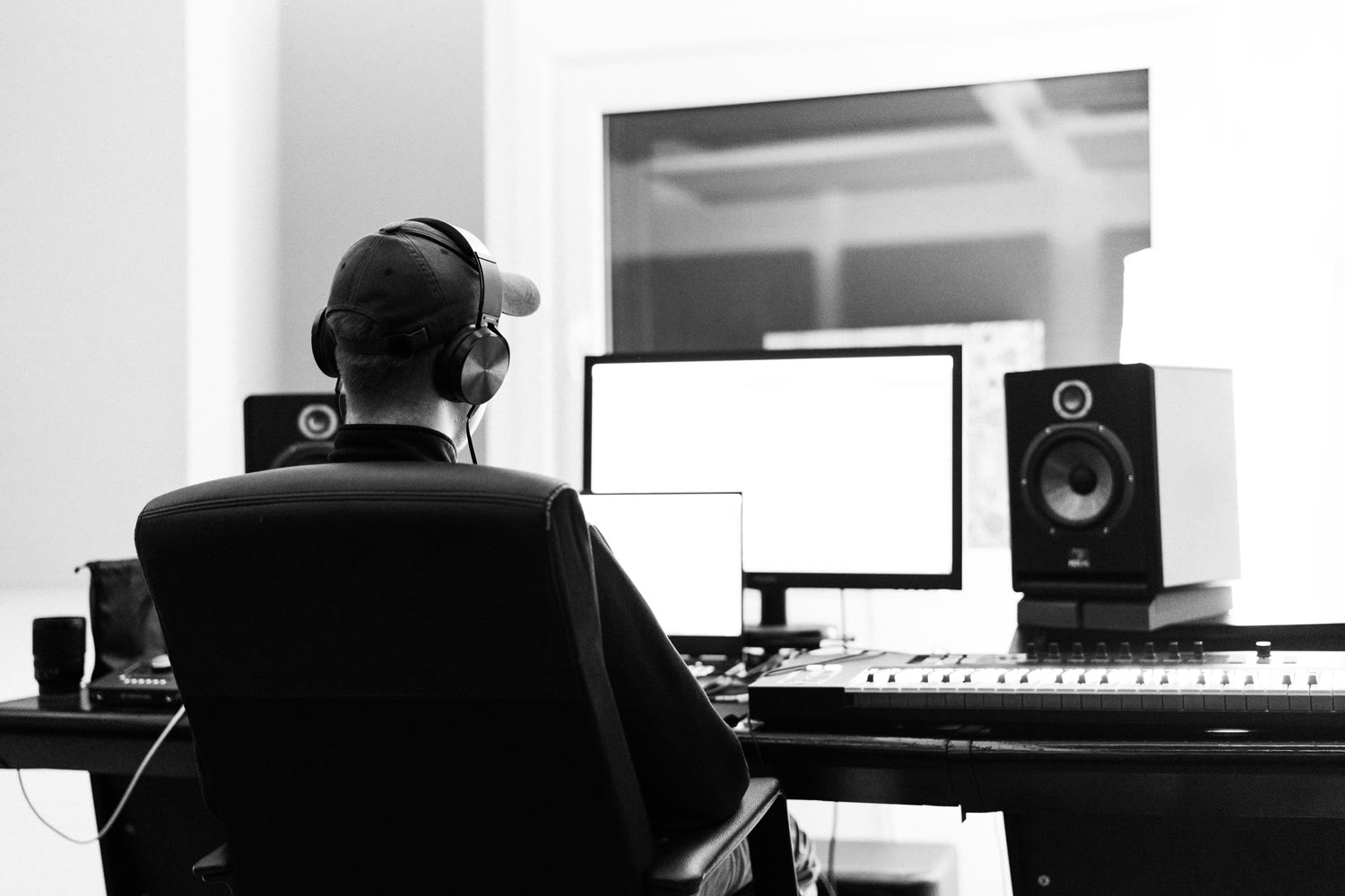madein2k working from behind at his studio desk — headphones, monitors and keyboard.